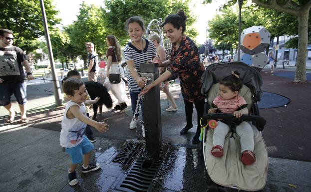 Varios niños se refrescan en una fuente pública de Bermeo. /maika salguero